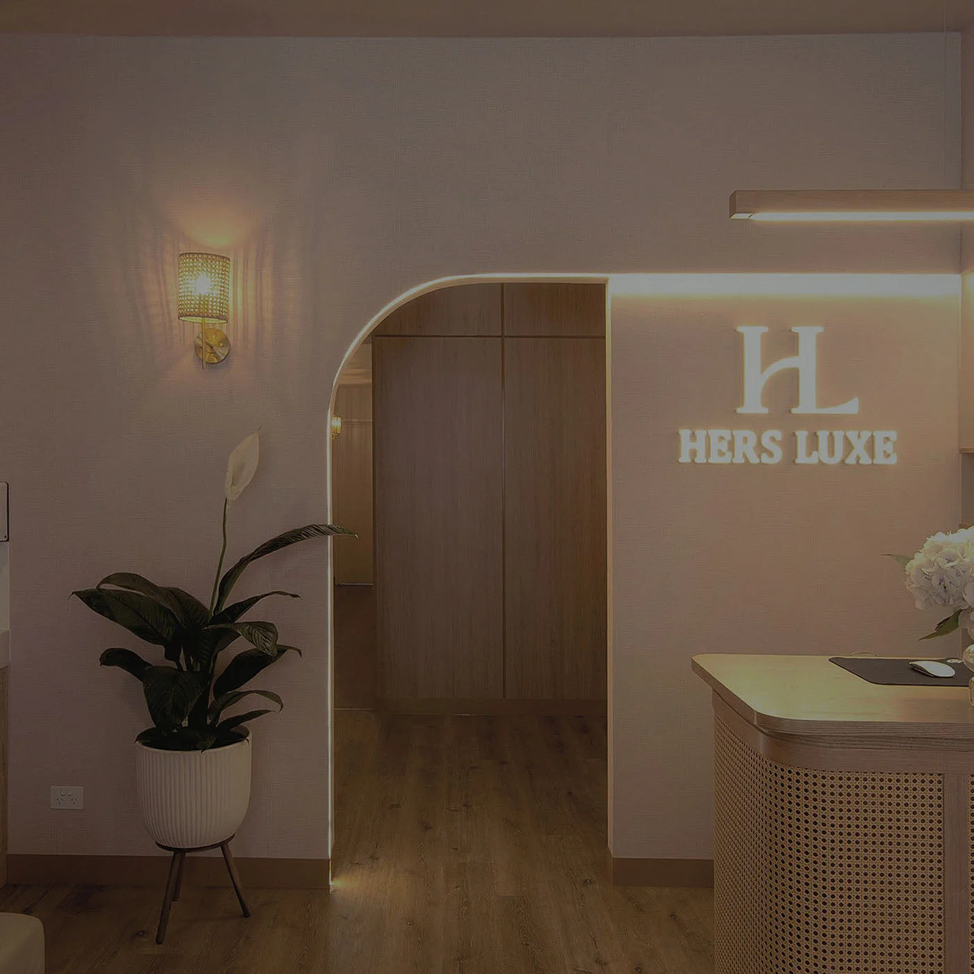 The glowing arch — Hers Luxe Camberwell reception with backlit HL sign