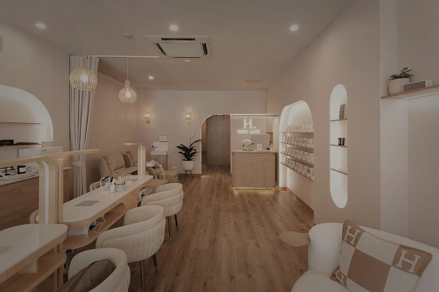 Hers Luxe nail salon — cream arched, backlit niches and manicure stations